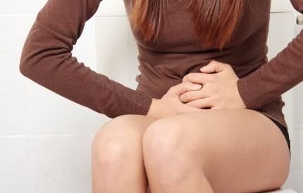 배를 누르고 있는 여성