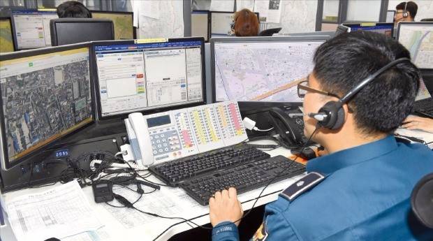 한 경찰관이 지난 26일 서울지방경찰청 112종합상황실에서 시민의 112 신고를 접수하고 있다. 경찰관이 신고자의 위치와 신고 내용을 가운데 화면에 입력하면 서울지역 31개 경찰서의 112종합상황실로 즉각 전달된다. 접수 경찰관은 정확한 위치 파악을 위해 왼쪽엔 지형 파악이 가능한 위성지도를, 오른쪽엔 신고자 위치와 가까운 순찰차 위치가 함께 뜨는 GPS 지도를 띄워놓는다. 김영우 기자 youngwoo@hankyung.com