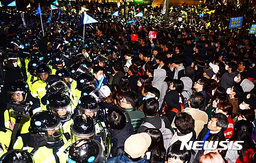 【서울=뉴시스】조성봉 기자 = 29일 오후 서울 종로구 청계광장에서 '모이자 분노하자 내려와라 박근혜' 촛불집회를 마친 시민들이 광화문 네거리에서 청와대를 향해 행진하며 경찰과 대치하고 있다. 2016.10.29.  suncho21@newsis.com