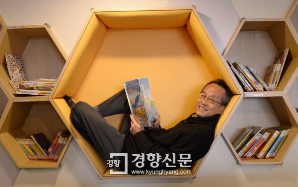 최재천 원장이 지난 17일 서천국립생태원 어린이 생태글방에서 벌집 모양의 서가에 들어가 책 읽는 포즈를 취하고 있다. 최 원장은 “어린이들이 관람 후 궁금한 것들을 책을 통해 확인할 수 있도록 전시실 앞 로비에 생태글방을 만들었다”고 말했다.  박민규 선임기자 parkyu@kyunghyang.com