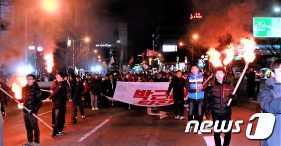3일 오후 '박근혜 즉각 퇴진 순천시민촛불 대회'에 참석한 시민들이 횃불을 들고 순천 시가지를 행진하고 있다. 이날 촛불집회에는 주최 측 추산 5000여명(경찰 추산 1500명)의 시민이 참석, '박근혜 퇴진'과 '이정현 퇴출'을 한목소리로 외쳤다.2016.12.3/뉴스1 © News1 지정운 기자