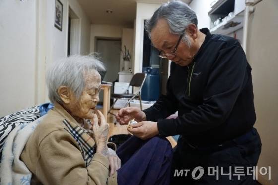 에세이 '나는 매일 엄마와 밥을 먹는다'를 출간한 저자 60대 정성기(오른쪽)씨가 치매를 앓는 90대 노모인 전정금씨 입안에 캐러멜을 넣어 드리고 있다. /사진=김지훈 기자