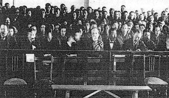 ‘시치조 기요미 컬렉션’에 있는 안중근 의사 재판 법정 사진. 앞줄 중간 벗어진 이마에 턱을 괴고 있는 사람이 량치차오다. 피고석은 비어 있어 안 의사가 법정에 나오기 전이다. 1910년 2월 7∼14일 사이의 사진이다.