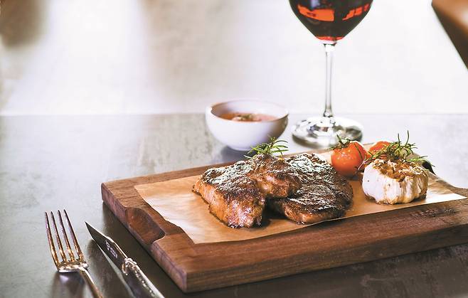 그랜드하얏트서울 호텔 ‘스테이크 하우스’의 돼지고기 목살구이. 14시간 저온 조리(수비드)하고 오븐에서 2차로 구워내 바삭한 질감과 부드러운 속살을 살렸다.