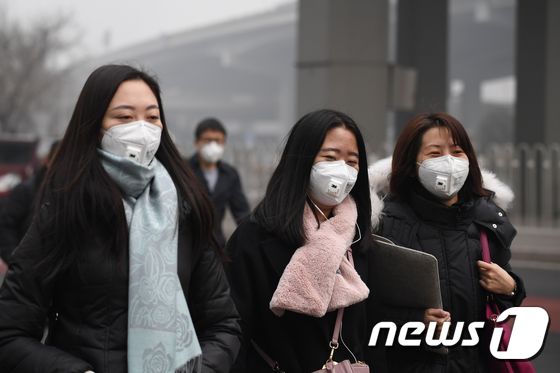 20일(현지시간) 중국 베이징에서 행인들이 마스크를 착용한 채 이동하고 있다. © AFP=뉴스1