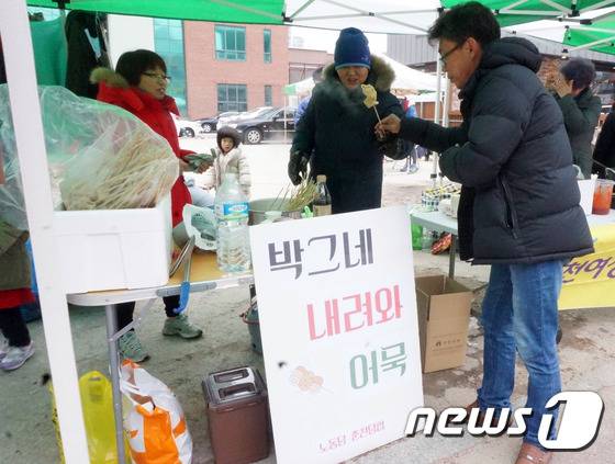 24일 오후 강원도춘천시 석사동 김진태 국회의원 사무실 앞에서 열린 ‘불우이웃 돕기 벼룩시장’에서 시민들이 ‘박그네 내려와 어묵’을 시식하고 있다.2016.12.24/뉴스1 © News1 박태순 기자