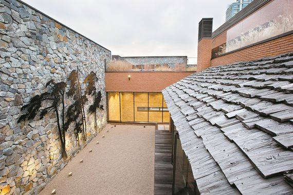 건물 옥상에 위치한 야외정원. 돌로 외벽을 쌓고 그 안에 억새와 자두나무, 소나무를 심었다. 중국·인도네시아 폐가에서 뜯어온 너와지붕이 이국적인 정취도 자아낸다.