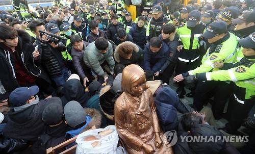 끌려나가는 소녀상 농성자        (부산=연합뉴스) 김선호 기자 = 부산 시민단체가 28일 부산 일본영사관 앞에서 기습적으로 소녀상을 설치한 가운데 구청 직원들이 소녀상에서 연좌농성을 벌이던 시민을 강제로 끌어내고 있다. 2016.12.28      wink@yna.co.kr