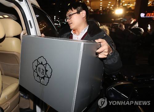 (서울=연합뉴스) 김도훈 기자 = '박근혜-최순실 게이트'를 수사하는 박영수 특별검사팀 관계자들이 28일 오후 서울 강남구 김영재 성형외과 원장 사무실 및 김 원장의 아내가 운영하는 와이제이콥스 메디컬 사무실에서 압수수색을 마친 뒤 압수품을 들고 건물을 나서고 있다. 2016.12.28      superdoo82@yna.co.kr