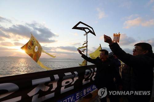 (진도=연합뉴스) 정회성 기자 = 세월호 참사 1천일째를 맞은 9일 오후 전남 진도군 팽목항 방파제에서 미수습자 가족 권오복(오른쪽)씨가 동생 재근씨의 귀환을 염원하며 연을 띄우고 있다.