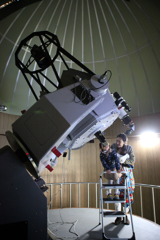 보현산천문과학관 주관측실에서 아이가 망원경을 통해 하늘의 별을 보고 있다<사진=영천시 제공>