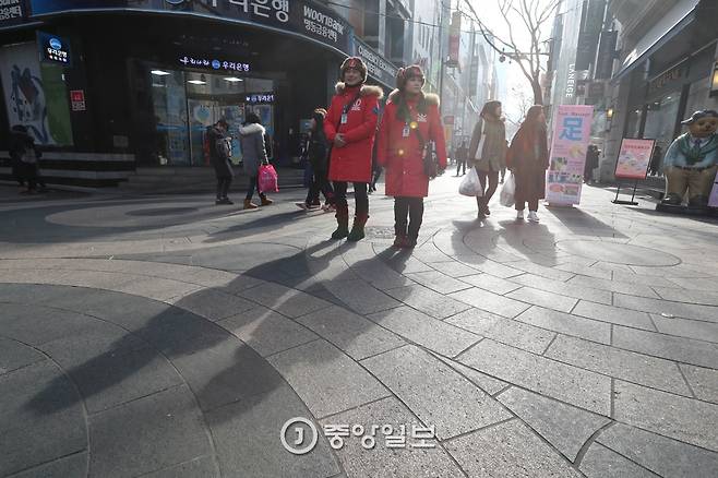 명동거리에서 근무하는 배승근(38,남,왼쪽)·박민진(32)씨 앞으로 겨울해에 비친 그림자가 길게 늘어졌다. 신인섭 기자