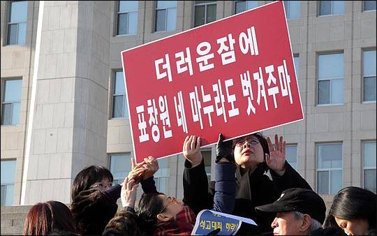 새누리당 전국여성의원협의회 소속 회원들이 25일 오후 국회 본청 앞 계단에서 박근혜 대통령이 묘사된 풍자 누드화 '더러운잠'이 전시된 풍자전시회로 논란을 빚은 표창원 의원의 사퇴를 요구하며 '더러운잠에 표창원 네 마누라도 벗겨주마'라고 씌여진 피켓을 들고 있다. ⓒ데일리안 박항구 기자