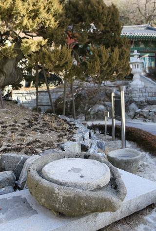 보문사 향나무 앞에 놓인 대형 맷돌.