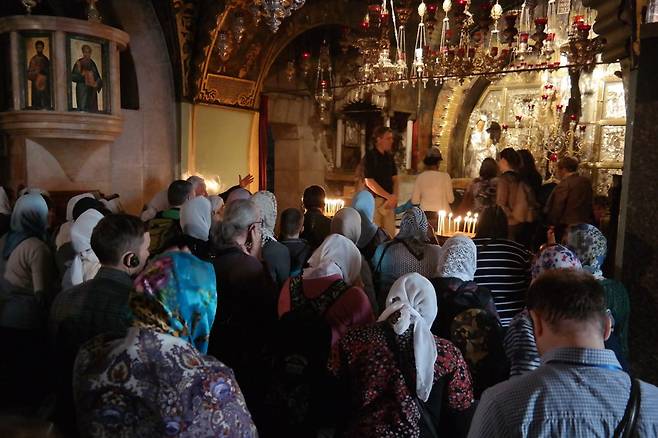 성묘교회의 십자가상 앞에서 순례객들이 기도를 하고 있다.