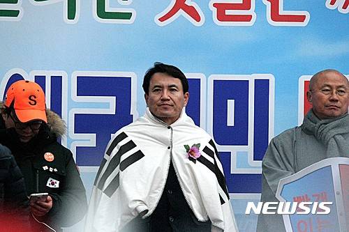 【춘천=뉴시스】조명규 기자 = 19일 오후 강원 춘천시 석사동 로데오사거리에서 열린 '춘천 애국시민 탄핵기각 태극기 집회'에서 자유한국당 김진태 의원이 태극기를 두르고 박근혜 대통령 탄핵 기각을 촉구하고 있다. 2017.02.19.   mkcho@newsis.com