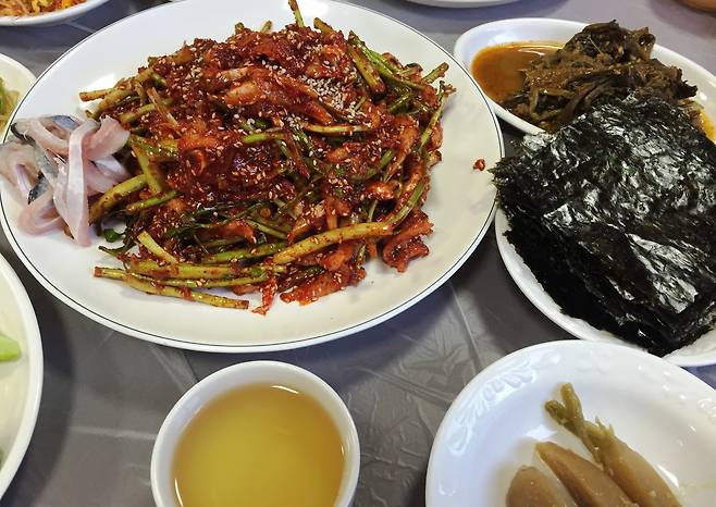 상에 오른 어우회무침. 날 김에 싸서 먹어도 좋다. 비교하기 위해 무치지 않은 우어 살을 옆에 놓았다(2015년 3월 7일 사진).