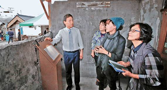 전주 선미촌 빈집에서 열린 설치미술전에서 소보람(모자 쓴 여성) 작가가 김승수 전주시장 등 관람객들에게 작품을 설명하고 있다. [사진 전주시]