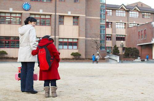 [헬스조선]아이가 머리나 배가 아프다며 등교를 거부한다면 새학기증후군일 수 있다./사진=헬스조선 DB(초등학교 앞의 엄마와 아이)