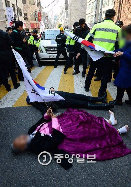 일부 집회 참가자들이 도로에 드러누워 취재차량의 통행을 막고있다.