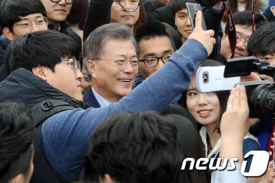 문재인 더불어민주당 대선주자가 20일 오후 광주 북구 용봉동 전남대학교 후문 광장에서 경선 홍보 영상을 찍은 뒤 학생들과 기념사진을 찍고 있다. 2017.3.20/뉴스1 © News1 황희규 기자