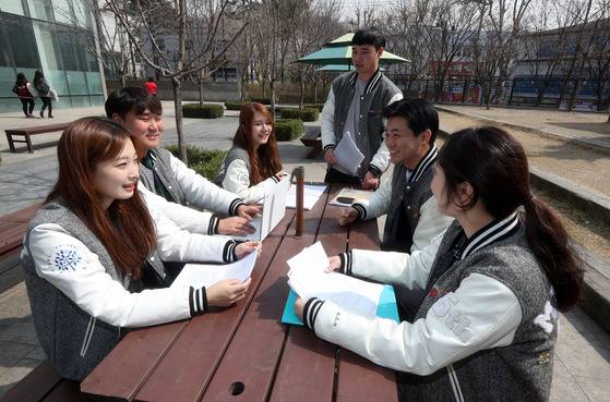 명지대 홍보기자단 동아리 회원들이 야외 테이블에 앉아 취재 계획 등과 관련한 회의를 하고 있다.