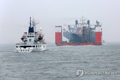 (목포 사진공동취재단=연합뉴스) 31일 오전 전남 진도군 동거차도 인근해상에서 반잠수식 선박 화이트마린 호에 실린 세월호가 전남 목포시 목포신항만을 향한 마지막 항해를 하고 있다.