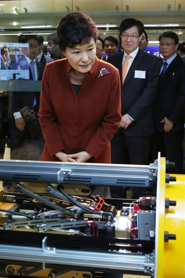 2014년 12월 17일 포항시 남구 지곡로 포스텍 C5에 있는 포항 창조경제혁신센터를 방문한 박근혜 전 대통령이 산업용 배관 청소로봇을 참관하고 있다.  박 전 대통령 뒤쪽으로 권오준 포스코회장이 보인다. 한국일보 자료사진