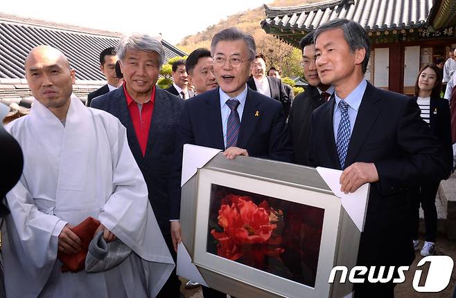 지난 4월 11일 당시 더불어민주당 대선 후보였던 문재인 대통령이 부산시 금정구 범어사를 찾아 불교미술가에게 그림을 선물받고 있다. 문 후보측은 선거법과 관련해 마음만 받겠다며 선물은 받지않았다고 밝혔다. 2017.4.11/뉴스1 © News1 허경