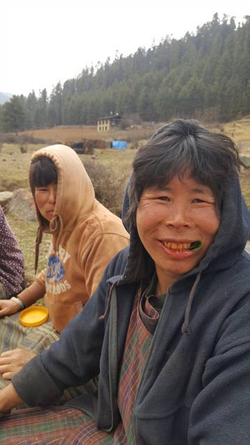 딱정벌레 너트 '도마'를 라임 잎에 싸서 씹고 있는 부탄의 아낙. 붉은 너트를 많이 씹으면 치아와 입술도 빨갛게 물든다.
