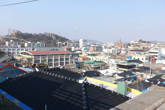 서산동 보리마당길에서 본 목포 원도심과 목포진 역사공원(3시 방향 나무와 기와집 있는 언덕). 그 중간 낮은 지역은 1900년대 초 도시개발 전에는 모두 농지였다. 가운데 놓은 건물이 옛 목포경찰서 자리에 들어선 초원실버타운이다.