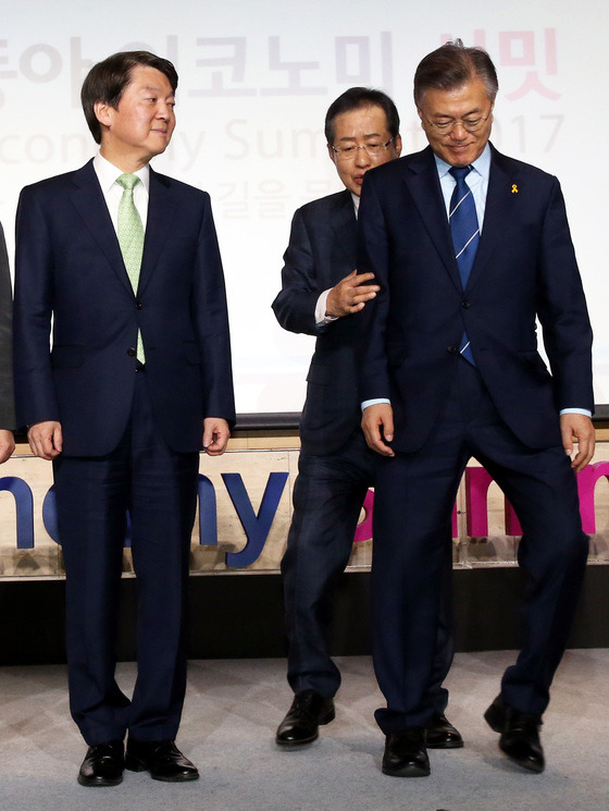 지난 12일 여의도 FKI콘퍼런스 센터에서 열린 2017 동아 비지니스 서밋에서 안철수 국민의당 대선후보와 문재인 더불어민주당 대선후보 사이로 홍준표 자유한국당 대선후보가 비집고 들어가려 하고 있다. [중앙포토]