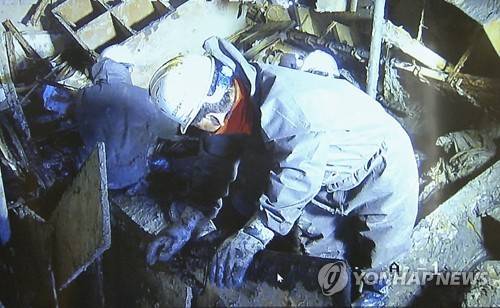 (서울=연합뉴스) 세월호 선내 수색작업 영상이 21일 오전 공개되고 있다. 진흙과 엉킨 집기류 등이 온통 짙은 회색빛을 띠고 있다. 열악한 공간에서 작업자들이 맨손과 간단한 도구를 이용해 작업을 벌이고 있다. 2017.4.21 [연합뉴스TV 제공 = 연합뉴스]      photo@yna.co.kr