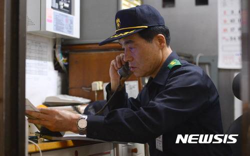 【서울=뉴시스】김선웅 기자 = 무인경비시스템 도입으로 해고 위기에 놓였던 경비원 283명 중 한명인 구자복 씨가 20일 서울 송파구 올림픽선수기자촌아파트 내 경비실에서 업무를 보고 있다. 2017.04.23.    mangusta@newsis.com