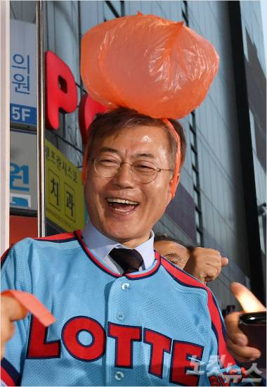 더불어민주당 문재인 대선 후보가 22일 부산 서면 젊음의 거리에서 롯데 응원문화의 상징인 비닐봉지를 쓴 뒤 미소짓고 있다. 박종민기자