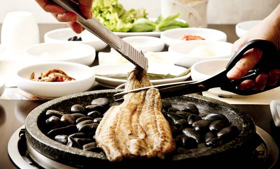 주방에서 센 불로 익힌 후 맥반석 돌판 위에 올려 손님상에 내는 송강 갯벌장어구이. 잘못 구워 껍질이 타거나 몸에 기름냄새가 배지 않는다. 긴경록 기자