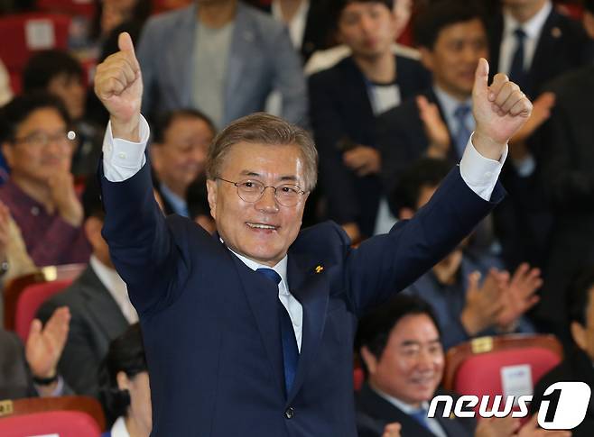 문재인 더불어민주당 대선 후보가 9일 서울 여의도 국회 의원회관에서 19대 대통령 선거 출구조사 방송을 보며 당원들의 환호에 두 팔 벌려 화답하고 있다. 2017.5.9/뉴스1 © News1 박지혜 기자