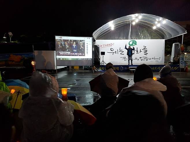 9일 저녁 8시 경북 성주군 성주읍 경산리 성주군청 건너편 주차장에서 열린 301일째 사드 배치 반대 성주 촛불집회에서 주민들이 함께 제19대 대통령선거의 지상파 3사 출구조사 결과를 지켜보고 있다.