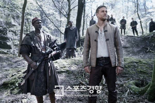 극 중 아서(오른쪽)와 그의 조력자들. 왼쪽은 배우 디몬 하운수. 사진 워너브러더스 코리아.