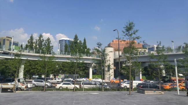 [사진설명=오는 20일 개장을 앞두고 막바지 작업이 한창인 서울로7017 너머로 서울스퀘어와 연세세브란스빌딩 등 대형 오피스 빌딩이 보인다.]