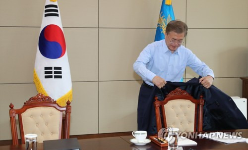 (서울=연합뉴스) 백승렬 기자 = 문재인 대통령이 25일 청와대 여민관 소회의실에서 열린 수석보좌관회의에서 상의를 벗어 의자에 걸고 있다.  srbaek@yna.co.kr