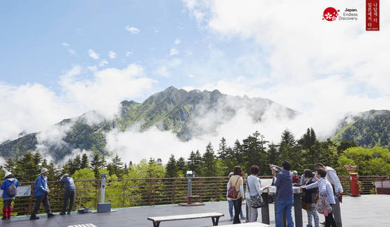 일본 100대 명산이라 불리는 도야마현 다테야마 연봉을 찾은 관광객이 경관을 감상하고 있다.