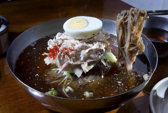 달인 간장으로 국물 간을 맞춘 뽀빠이냉면. 고명으로 닭고기와 돼지고기를 두툼히 얹어준다. 임현동 기자