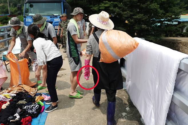 건조된 옷가지를 들고 가고 있는 김정숙 여사. [사진 청와대]