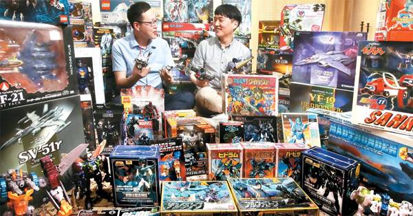 트랜스포머 피겨를 주로 수집하는 김영기·김현기 형제가 수집한 장난감들과 포즈를 취하고 있다.