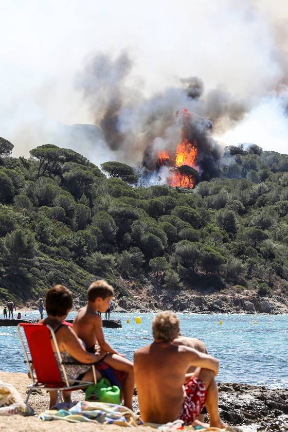 프랑스 남부 연안도시 상트로페 인근에서 해수욕을 즐기던 휴양객들이 25일(현지시간) 가까운 산 위로 치솟은 불길을 바라보고 있다. [AFP=연합뉴스]