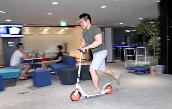 카카오뱅크 사무실에서 킥보드를 타고 이동하는 지상민씨. 반바지에 티셔츠 차림의 그는 리스크를 담당하는 뱅커다. 사무실에서의 킥보드 이동이 카카오뱅크의 속도 경영을 상징적으로 보여 주는 듯하다. [최정동 기자]