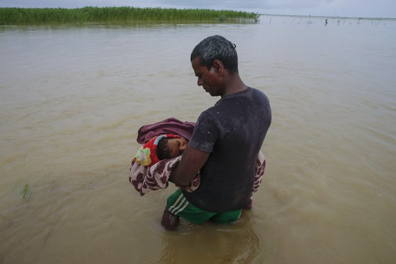 네팔 홍수로 폐렴을 앓다 숨진 8살 조카를 코시 강에 데려간 삼촌. 마른 땅이 남아 있지 않아 묻을 곳이 없어 강물 장례를 치렀다. [EPA=연합뉴스]