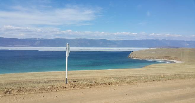 ‘성스러운 바다’ ‘세계의 민물 창고’ ‘시베리아의 푸른 눈’ 같은 별명답게 바이칼 호수가 다채로운 물 색깔을 뿜어내며 출렁이고 있다. 흙길 위에 완고히 서 있는 교통 표지판도 유목민처럼 마구 오가는 바람을 막진 못할 것이다. / 이병철