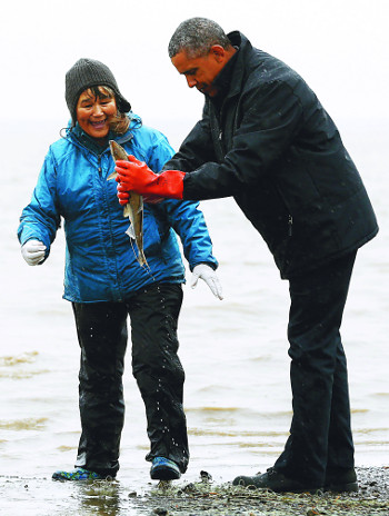 버락 오바마 미국 대통령이 2일(현지시간) 세계 최대 홍연어 어장이 있는 알래스카주 딜링엄 누샤각강에서 어민에게 새끼 연어를 받아 만져보고 있다. 로이터연합뉴스
